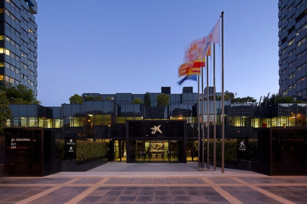 Edificio de CaixaBank en Europa con banderas ondeando
