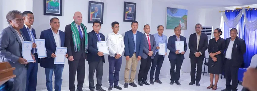 Grupo de personas firmando acuerdos en Timor Oriental