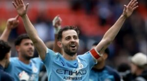Bernardo Silva celebrando con los brazos en alto tras un partido de fútbol.