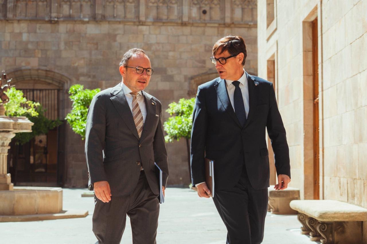 Dos hombres conversando en un entorno arquitectónico en Cataluña