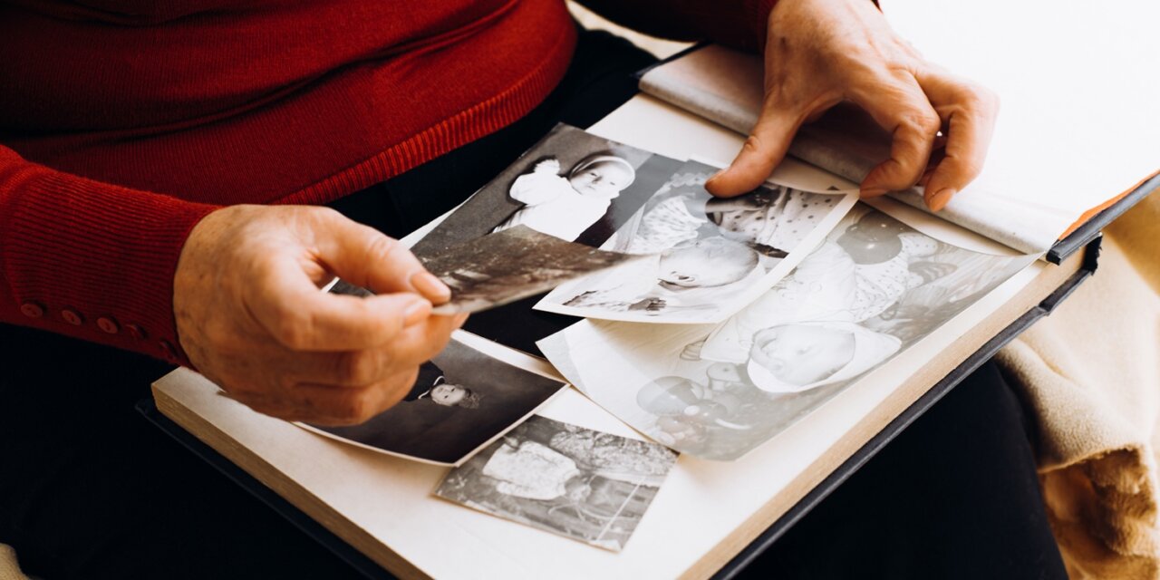 Persona revisando fotos antiguas en un álbum familiar