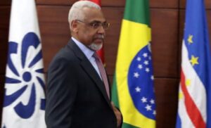 Hombre caminando junto a banderas de países de la CPLP