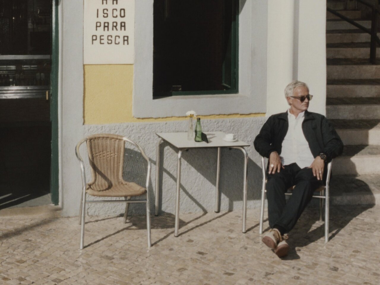 José Mourinho sentado en una cafetería, con gafas de sol y una actitud relajada.
