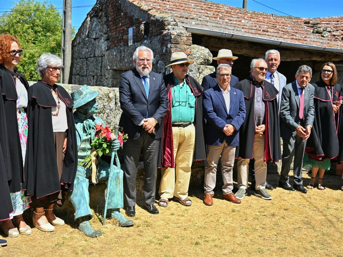 Acto en el Couto Mixto con figuras destacadas y una escultura