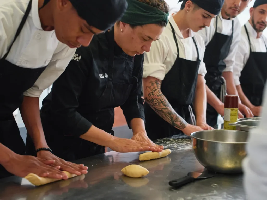Grupo de personas en una clase de cocina trabajando en la masa