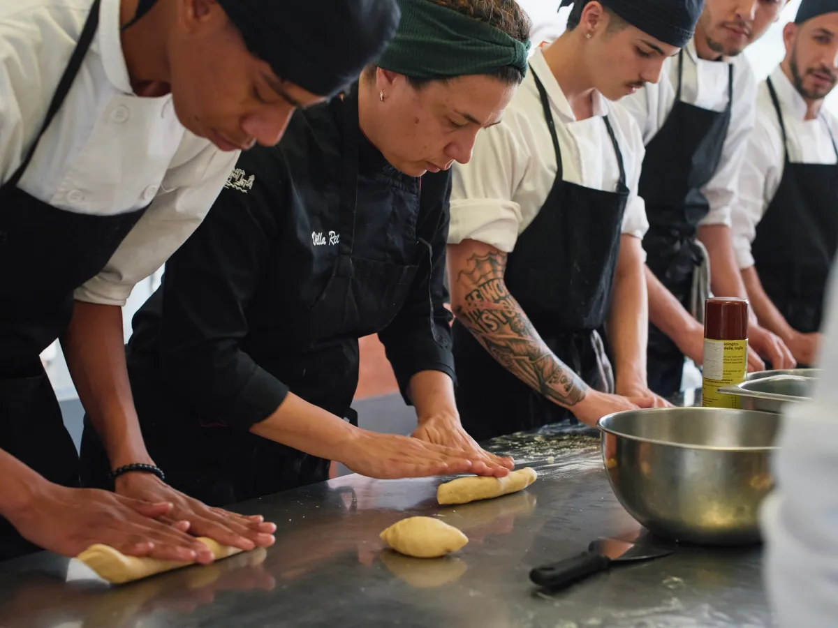 Grupo de personas en una clase de cocina trabajando en la masa