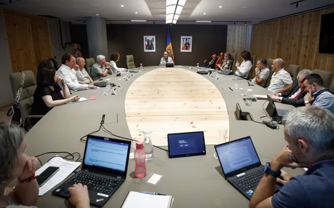 Reunión del Pacto de Estado en Andorra con varios participantes en una mesa ovalada.