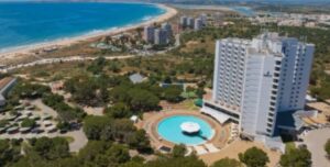 Vista aérea de um hotel do grupo Pestana em Portugal com piscina e mar ao fundo