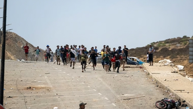 Grupo de personas corriendo en una zona afectada por la crisis migratoria
