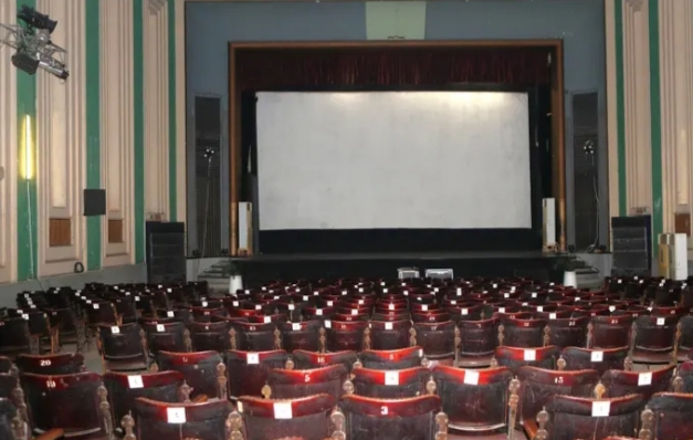 Vista del interior de una sala de cine con asientos y pantalla en blanco