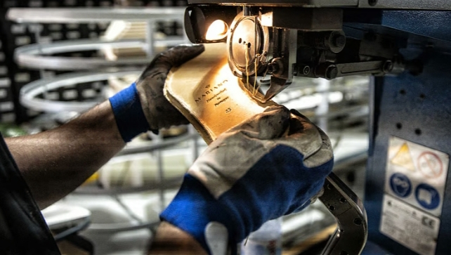 Mano sosteniendo una plantilla de zapato en una fábrica de calzado