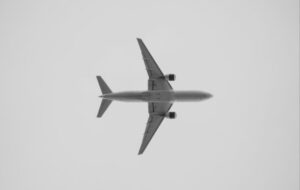 Avión volando sobre un fondo gris en el cielo.
