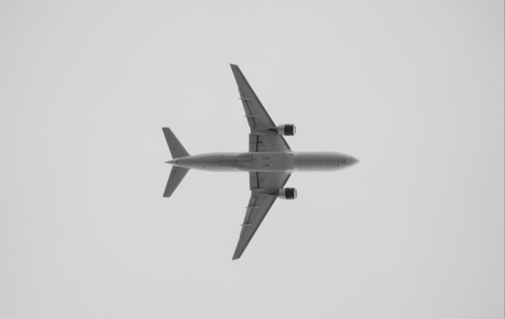 Avión volando sobre un fondo gris en el cielo.
