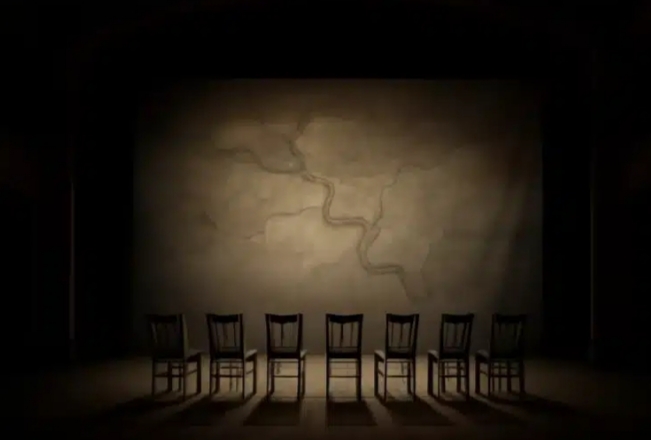 Escena con sillas en un escenario oscuro para festival literario