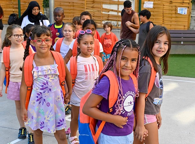 Niños con mochilas naranjas en un entorno escolar