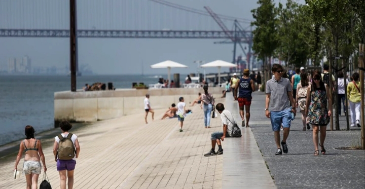 Paseo junto al río con personas disfrutando del clima en Portugal