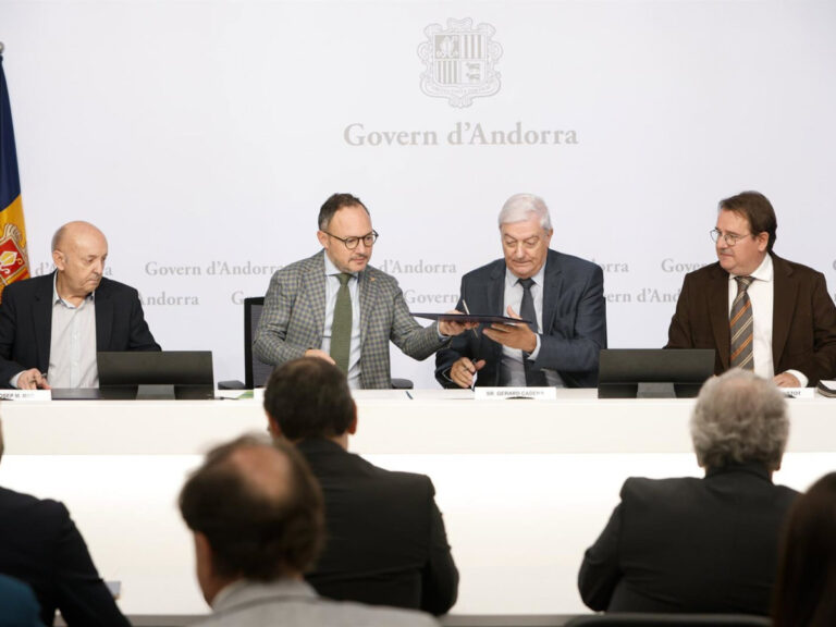 Varios hombres comparten un documento ante el rótulo del Gobierno de Andorra