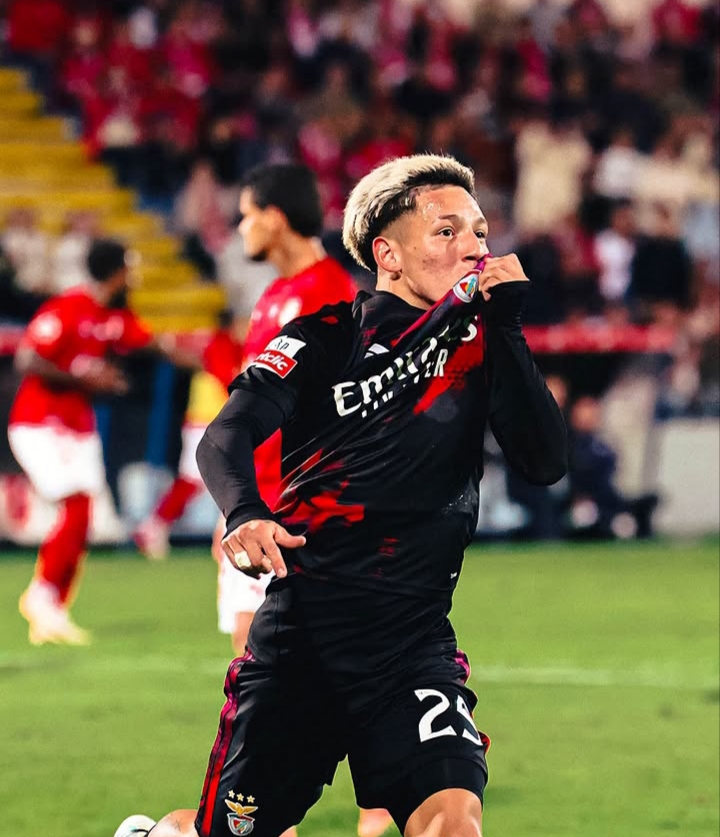 Futbolista del Benfica besa el escudo de su camiseta durante un partido