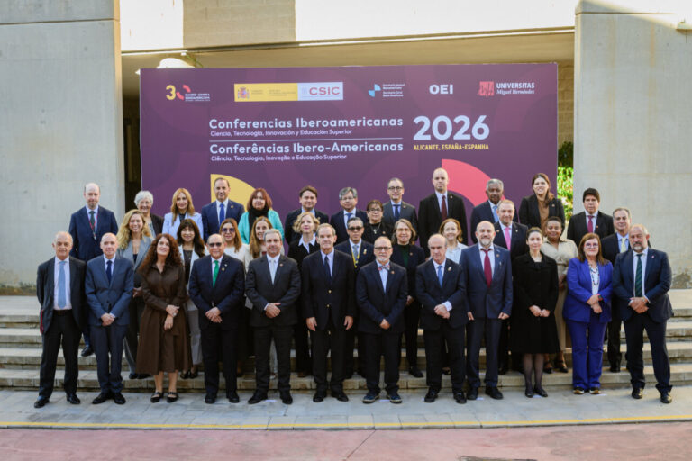 Grupo de asistentes posa ante el cartel de las Conferencias Iberoamericanas 2026 en Alicante.