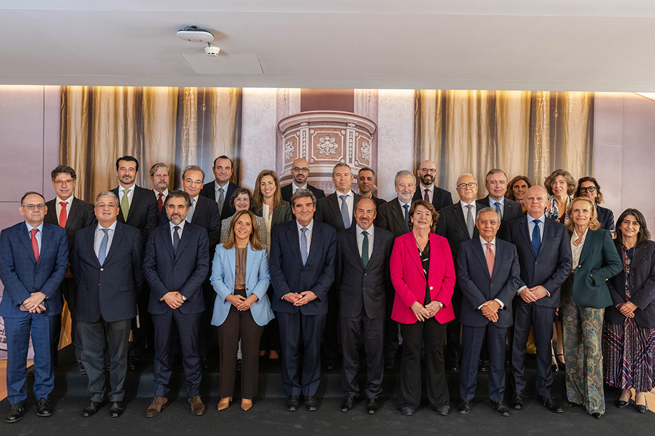 Grupo numeroso de personas posando en varias filas dentro de una sala