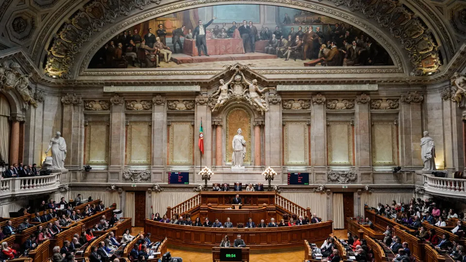 Vista amplia del hemiciclo portugués con asistentes sentados bajo una decoración monumental