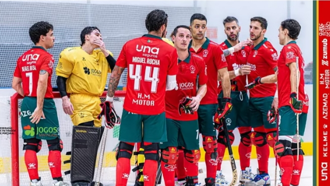 Jugadores de hockey sobre patines con uniforme rojo reunidos junto a la portería
