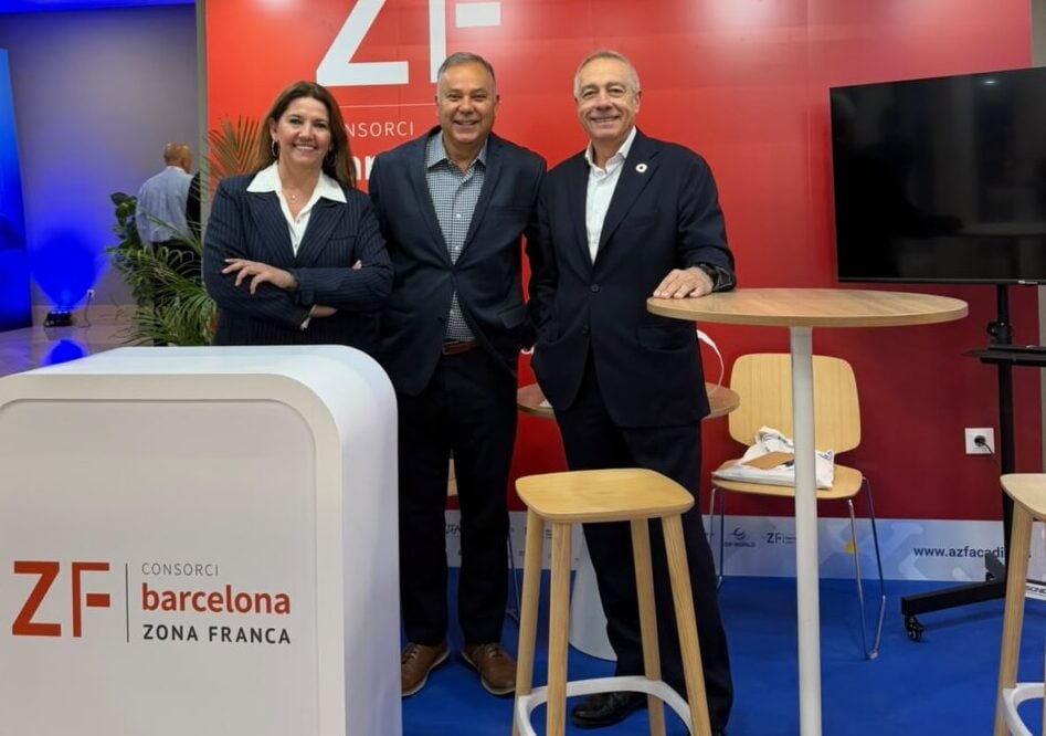 Tres personas posan junto al mostrador del Consorci de la Zona Franca de Barcelona